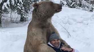 棕熊雪地霸氣環抱男子　畫面羨煞眾人