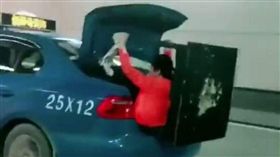 大陸一名鄭姓計程車司機為了送餐桌給女兒，竟讓老婆當「人肉固定架」，坐在後車箱扶著桌子。警方接獲通後，分三路圍堵將車查扣，最後鄭男被扣2分，罰200元人民幣（約新台幣920元）。（圖／翻攝自微博）