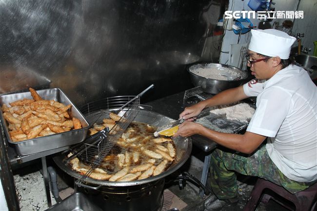 老闆吳坤道每天親自手工一條一條切出棒狀份量十足新鮮旗魚黑輪。（記者邱榮吉/攝影）