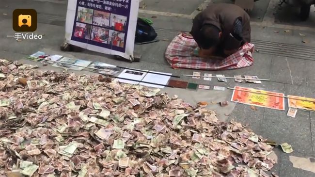男跪趴鈔票山旁行乞　網驚：比我有錢