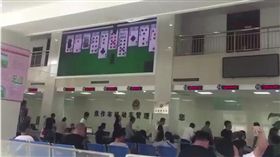 大陸河南交警機動車管理所大廳，27日大廳螢幕突然出現「電腦撲克接龍」遊戲畫面，更誇張的是，滑鼠還在操作撲克牌，讓一旁等候辦事的民眾全看傻眼。目前玩遊戲的員警以及2名責任民警已被停止執行職務，將接受進一步調查。（圖／翻攝自澎湃新聞）
