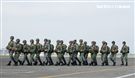 傘兵學員揹著降落傘整齊劃一步伐登機。（記者邱榮吉/屏東拍攝）