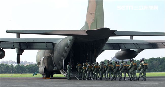 傘兵學員揹著降落傘整齊劃一步伐登機。（記者邱榮吉/屏東拍攝）