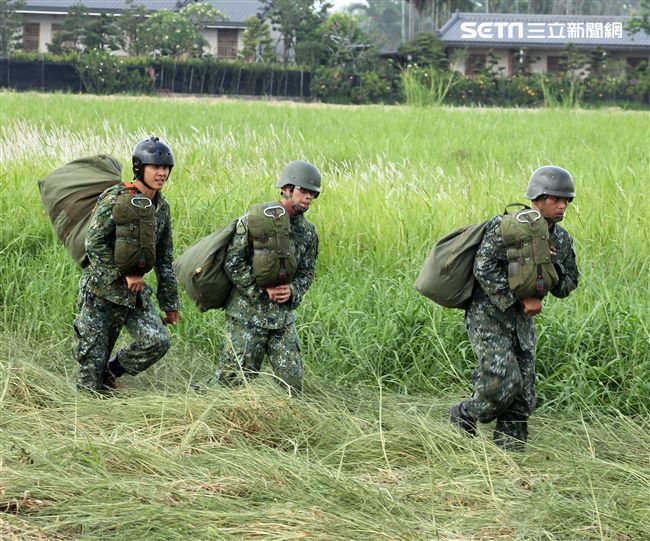 傘兵學員著陸後揹著自己的傘具到集合點。（記者邱榮吉/屏東拍攝）