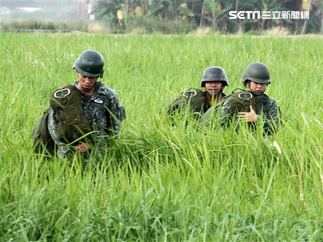 傘兵學員著陸後揹著自己的傘具到集合點。（記者邱榮吉/屏東拍攝）