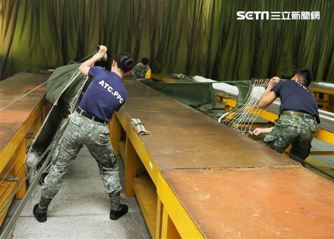 保傘連摺傘人員很細心的將每一條傘繩整理好，讓跳傘的弟兄無後顧之憂。（記者邱榮吉/屏東拍攝）