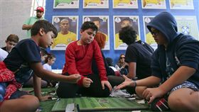 迎接世足賽熱潮，義工廠趕工製作球員貼紙。（圖/達志影像）