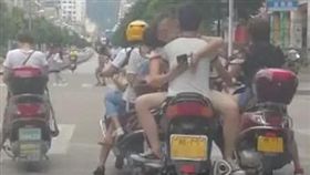 大陸河池市一對男女雙載騎車，但女方沒坐在後座，反倒開腿坐在男方大腿，姿勢呈現「觀音坐蓮」，讓不少目擊民眾看得臉紅心跳。最後警方依無照駕駛、未帶安全帽、坐姿違規、影響駕駛人安全等理由，處罰這對男女。（圖／翻攝自微博）
