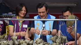 馬英九新北三重包粽子前總統馬英九（右2）26日前往新北市三重區大同南路市場為國民黨市議員參選人王威元助選，並前往人安基金會三重平安站，在志工指導下包粽子。馬英九說，雖然自己包的粽子不好看，但很好吃。中央社記者黃旭昇新北市攝　107年5月26日