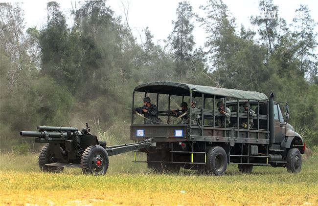 105公厘牽引榴彈砲在3.5頓戴重車牽引下機動進入砲陣地。（記者邱榮吉/金門拍攝）