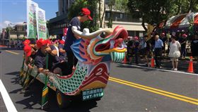 陸上飆龍舟　新竹關西有趣划槳樂（2）新竹縣關西鎮16日舉辦第2屆陸上龍舟賽，裝有輪子的龍舟在隊員們的奮力「划槳」下，朝終點滑行，吸引民眾圍觀加油。中央社記者魯鋼駿攝　107年6月16日