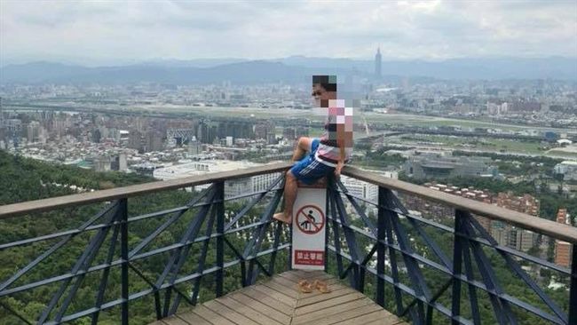 無視告示牌　墨鏡哥爬觀景台護欄耍帥