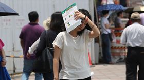 天氣炎熱  民眾遮陽（1）受到太平洋高壓籠罩影響，全台17日仍屬高溫炎熱的天氣，太陽高掛，民眾拿起手中物品遮陽。中央社記者張皓安攝  107年5月17日