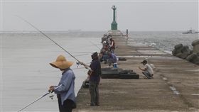 高雄風雨前寧靜（2）根據中央氣象局21日清晨最新海上颱風警報資料，2017 年第13號的輕度颱風天鴿正朝台灣靠近，下午起就會影響東半部及南部。圖為高雄21日中午無風無雨，釣魚客在防波堤釣魚。中央社記者董俊志攝　106年8月21日