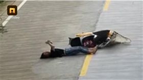 中國大陸一名女騎士摔車後竟直接躺在地上滑手機,車禍（圖／翻攝自梨視頻）