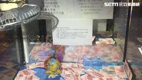 娃娃機業者又出新招！台南有一台娃娃機相當特別，它的爪子被改裝成電風扇，裡面的獎品則是滿滿的「百元鈔」，玩的人可以利用風力把鈔票吹進洞口。不過有網友質疑，這樣的玩法可能會違法，對此，警方已上門關切，將會請相關單位來裁決是否違法。（圖／翻攝照片）