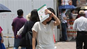 天氣炎熱  民眾遮陽（1）受到太平洋高壓籠罩影響，全台17日仍屬高溫炎熱的天氣，太陽高掛，民眾拿起手中物品遮陽。中央社記者張皓安攝  107年5月17日