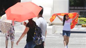 北部晴朗炎熱（1）中央氣象局預報，14日北部平地天氣大致晴朗穩定，大台北與高屏地區有機會出現高溫36度，台北市中午炙熱，民眾紛紛撐傘、拿起布條避烈日。中央社記者謝佳璋攝　107年7月14日