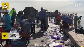 大陸青海烏蘭縣「天空之鏡」茶卡鹽湖，被《中國國家地理》評為一生必去的55個地方，但參觀的遊客非常沒公德心，竟無視垃圾桶，將穿過的鞋套遍地亂扔，導致景區工作人員每日要工作13小時清理垃圾。（圖／翻攝自梨視頻）