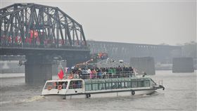 中國赴北韓遊客大增　一日遊最熱門在中國政府解禁後，6月赴北韓旅遊的陸客人數大增，其中又以丹東出發的一日遊最受歡迎。圖為丹東遊艇載滿遊客橫渡鴉綠江，要去一覽對岸的新義州風光。（中新社提供）中央社　107年6月28日