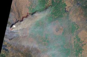 今年盛夏時節加州野火肆虐，由美國衛星「測地8號」的實用陸地成像儀自外太空所拍攝的照片顯示，加州大火捲起的煙塵如火山爆發，遮蔽了大氣層的最底層。（圖／翻攝自NASA網站 www.nasa.gov）