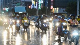 高雄仍持續降雨（1）台灣南部地區連日降雨，雨勢不小，20日傍晚高雄市區仍持續下著雨，民眾戴上帽子、撐著傘過馬路。中央社記者董俊志攝　107年6月20日