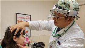 亞大醫院耳鼻喉部部長田輝勣替患者配戴助聽器。（圖非當事人／亞大醫院提供）