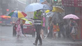 北市午後陣陣大雨中央氣象局10日預報，受熱帶性低氣壓及外圍環流影響，北部及東半部整天會有陣雨或雷雨，並有局部大雨或豪雨。台北市午後下起陣陣大雨，放學的小學生撐傘過馬路。中央社記者王飛華攝　107年9月10日