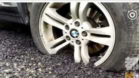 大陸陝西西安市高新區日前有一路段出現坑洞，造成不少騎士、用路人的困擾。當地政府派人施工時，發現人行道上有一輛BMW停了10幾日，嚴重影響施工進度。最後工人聯繫不到車主，只好鋪上滾燙瀝青施工，BMW的輪胎就慘被「活埋」。不少網友看到後，紛紛拍手叫好，直喊「痛快！」（圖／翻攝自微博）