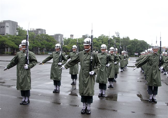 三軍儀隊穿著雨衣冒著雨為107年國慶大會預演，以幸福共好為主題操演高難度各種變換隊形。（記者邱榮吉/攝影）