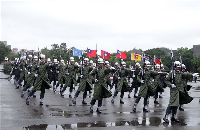 三軍儀隊穿著雨衣冒著雨為107年國慶大會預演，以幸福共好為主題操演高難度各種變換隊形。（記者邱榮吉/攝影）