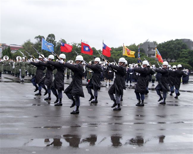 三軍儀隊穿著雨衣冒著雨為107年國慶大會預演，以幸福共好為主題操演高難度各種變換隊形。（記者邱榮吉/攝影）