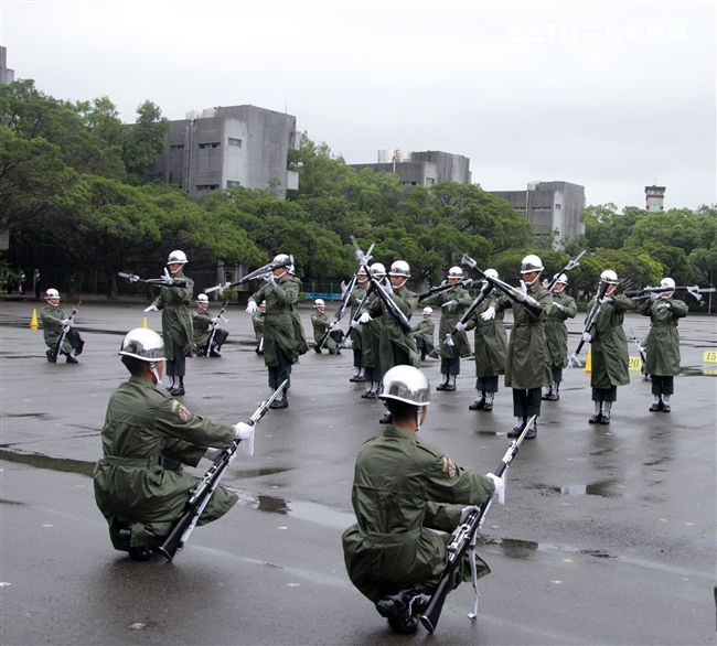 三軍儀隊穿著雨衣冒著雨為107年國慶大會預演，以幸福共好為主題操演高難度各種變換隊形。（記者邱榮吉/攝影）