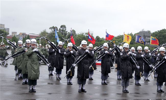 三軍儀隊穿著雨衣冒著雨為107年國慶大會預演，以幸福共好為主題操演高難度各種變換隊形。（記者邱榮吉/攝影）