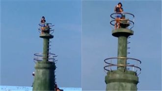 女攀燈塔拍照　還興奮向漁船揮手　　