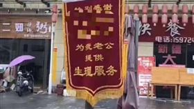 「錦旗」是一種榮譽的象徵，但大陸湖北街頭竟出現另類錦旗，上面寫上「感謝某銀行人員XXX，為我老公提供生理服務」。外界推測，這是正宮向「小三」的報復，讓對方顏面盡失。目前該銀行已對員工啟動內部調查，而當地警方正在調查釐清中。（圖／翻攝自微博）