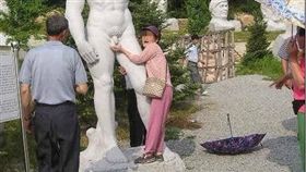 「老司機」阿嬤摸雕像好興奮。（圖／翻攝自爆廢公社）