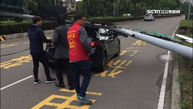 強風襲新竹！紅綠燈桿一棒壓扁小客車