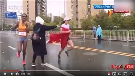 ▲中國跑者何引麗路跑中被工作人員塞五星旗。（圖／翻攝自华人TV官方频道）
