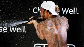 漢彌爾頓在封關站頒獎台上展現身上的刺青。（圖／翻攝自F1官網）