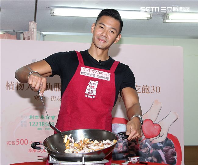 陳建州（黑人）做道地的客家小炒，提前與弱勢同桌圍爐，呼籲民眾小額捐款「搶救」尾牙宴。（記者邱榮吉/攝影）