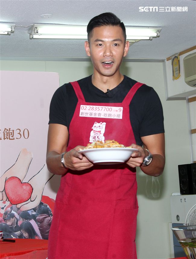 陳建州（黑人）做道地的客家小炒，提前與弱勢同桌圍爐，呼籲民眾小額捐款「搶救」尾牙宴。（記者邱榮吉/攝影）