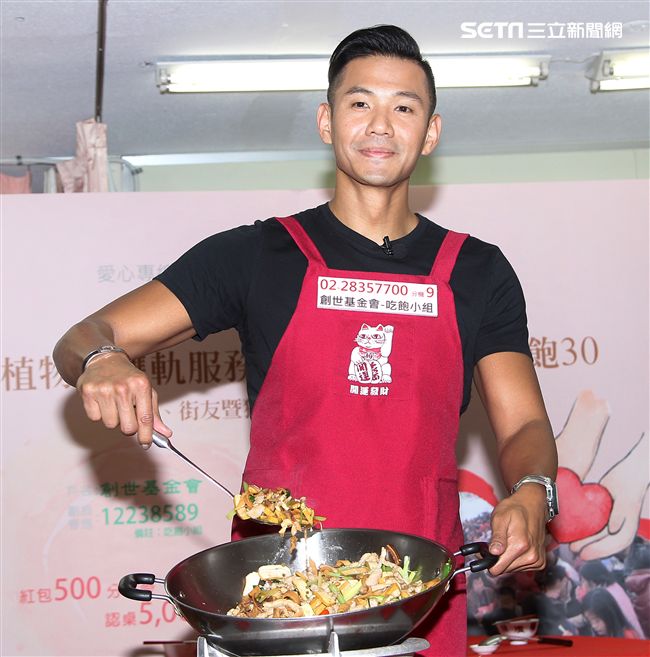 陳建州（黑人）做道地的客家小炒，提前與弱勢同桌圍爐，呼籲民眾小額捐款「搶救」尾牙宴。（記者邱榮吉/攝影）