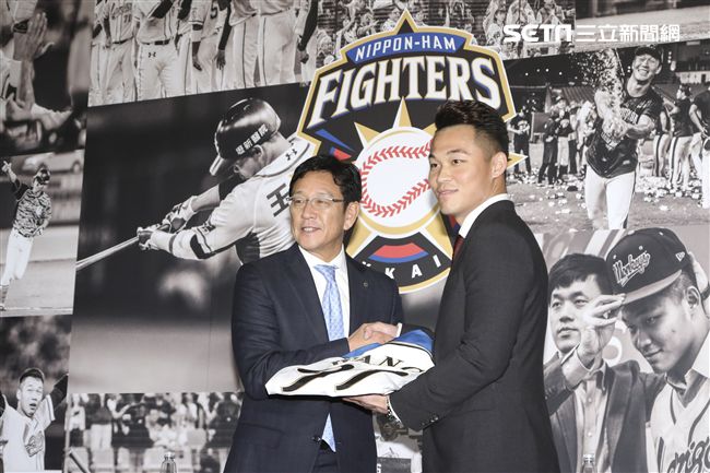 台灣強打王柏融與日本職棒火腿隊簽約，日本火腿球團監督栗山英樹遞上背號99號新球衣以及帽子。（記者林士傑/攝影）