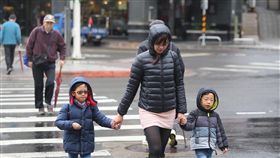 天氣濕冷氣溫低　民眾穿上冬衣禦寒（1）中央氣象局表示，30日清晨各地氣溫仍低，白天起冷空氣強度稍減弱，但因雲多下雨，整體來說氣溫回升幅度不大。民眾穿上厚重的衣服禦寒，穿梭在濕冷的台北街頭。中央社記者徐肇昌攝　107年12月30日