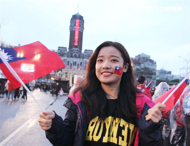 正妹臉上貼著國旗貼圖手上揮著國旗參加中華民國108年元旦升旗典禮。（記者邱榮吉/攝影）