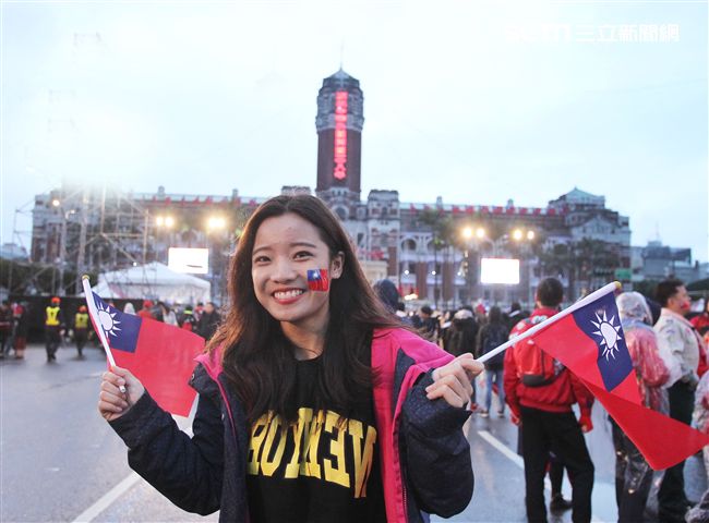 正妹臉上貼著國旗貼圖手上揮著國旗參加中華民國108年元旦升旗典禮。（記者邱榮吉/攝影）