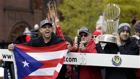  Alex Cora在遊行上舉起波多黎各國旗。（圖／美聯社／達志影像)