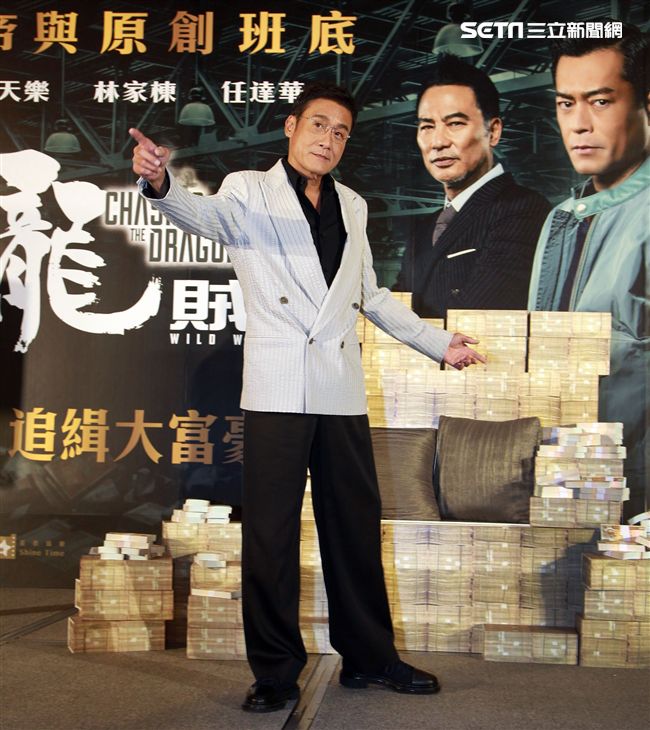 梁家輝出席電影「追龍II賊王」記者會，霸氣帥坐在鈔票椅瀟灑狂噴鈔票，展現史上最強悍匪氣魂。（記者邱榮吉/攝影）