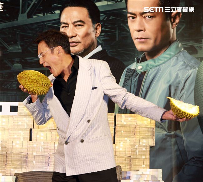 梁家輝因拍「追龍II賊王」的戲吃了三箱榴槤，電影公司特別在記者會現場讓梁家輝剝榴槤讓他想逃。（記者邱榮吉/攝影）